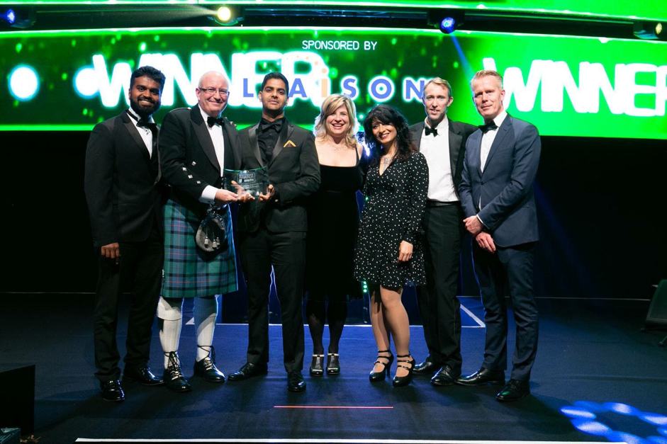 People accepting an award on a stage.