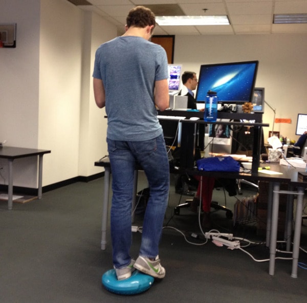 Someone balancing on one leg at their standing desk.